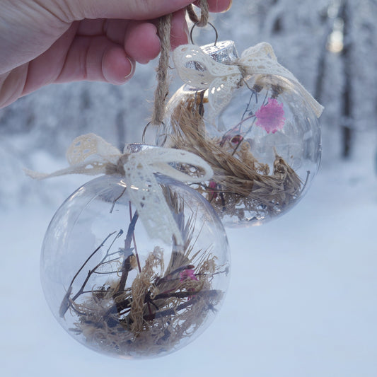 duo de boules en plastiques contenant des herbes et fleurs séchées