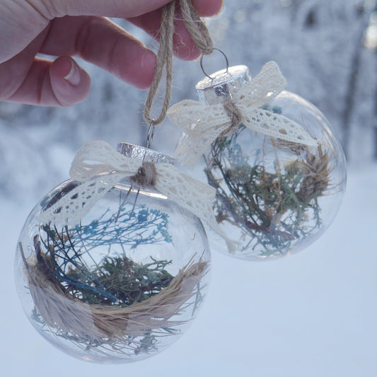 duo de boules en plastiques contenant des herbes et fleurs séchées