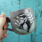 Tasse grise pic chevelu entouré de verdure