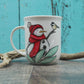 Petite tasse bonhomme de neige avec tuque et foulard rouge