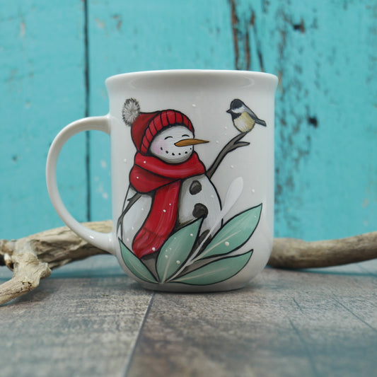 Petite tasse bonhomme de neige avec tuque et foulard rouge
