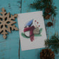 Carte de vœux geai bleu avec foulard rouge et branches de sapin